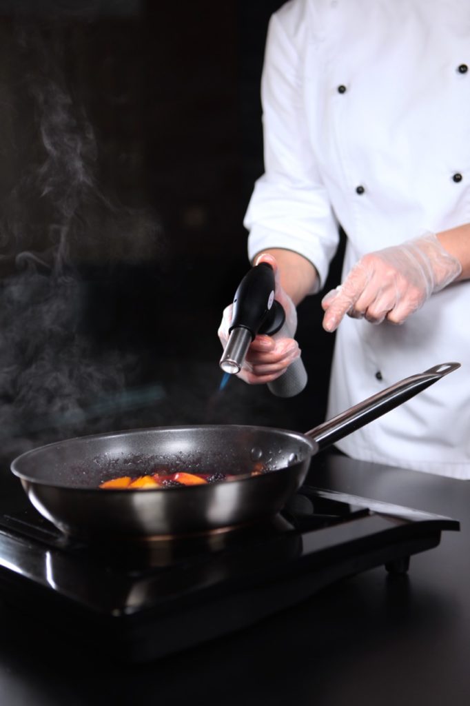 Chef cooking flambe dessert at fundraiser