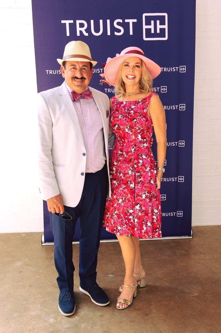 People wearing race day attire at day at the races fundraiser event.