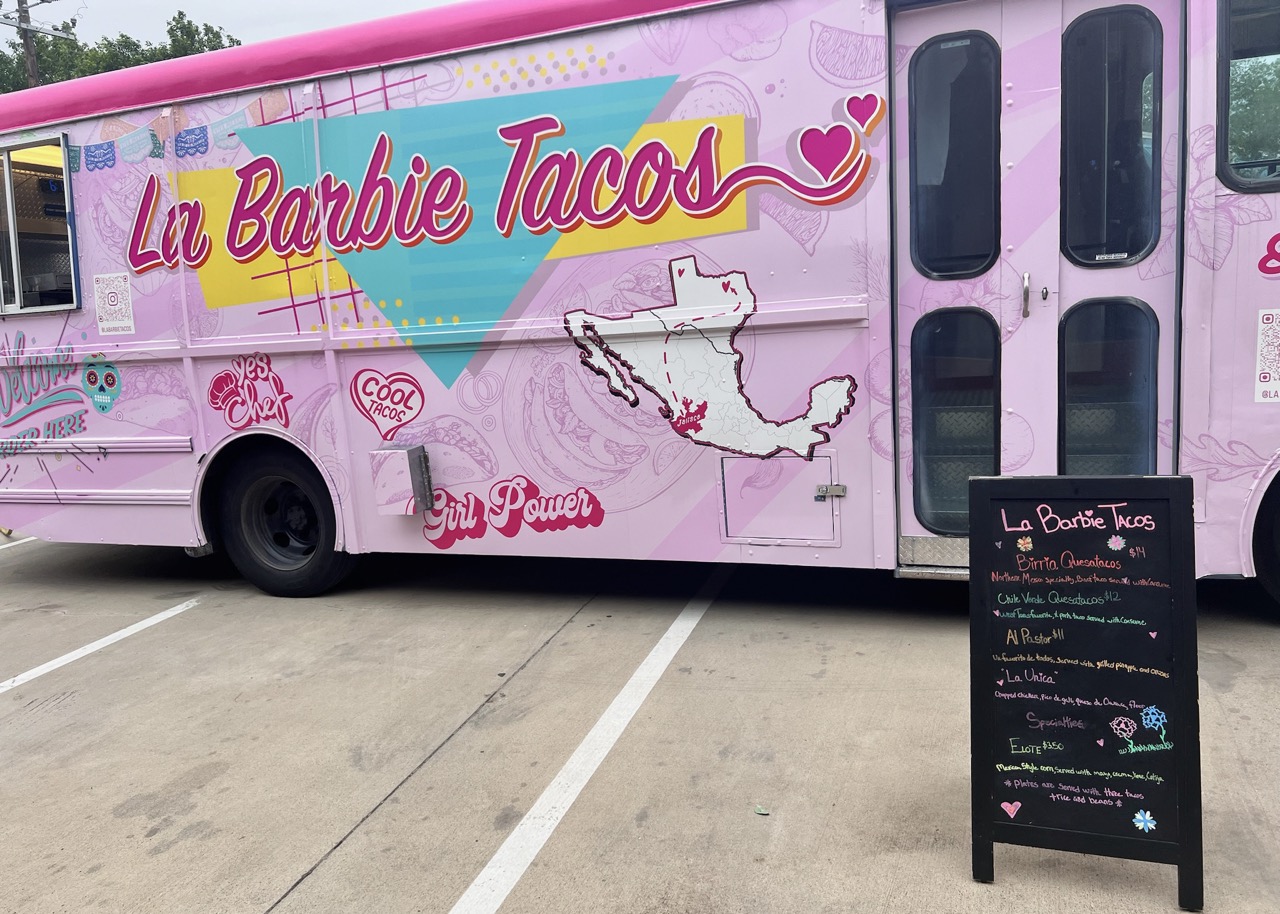 A pink food truck with a sign that says La Barbie Tacos at a Barbie-Themed Fundraiser event