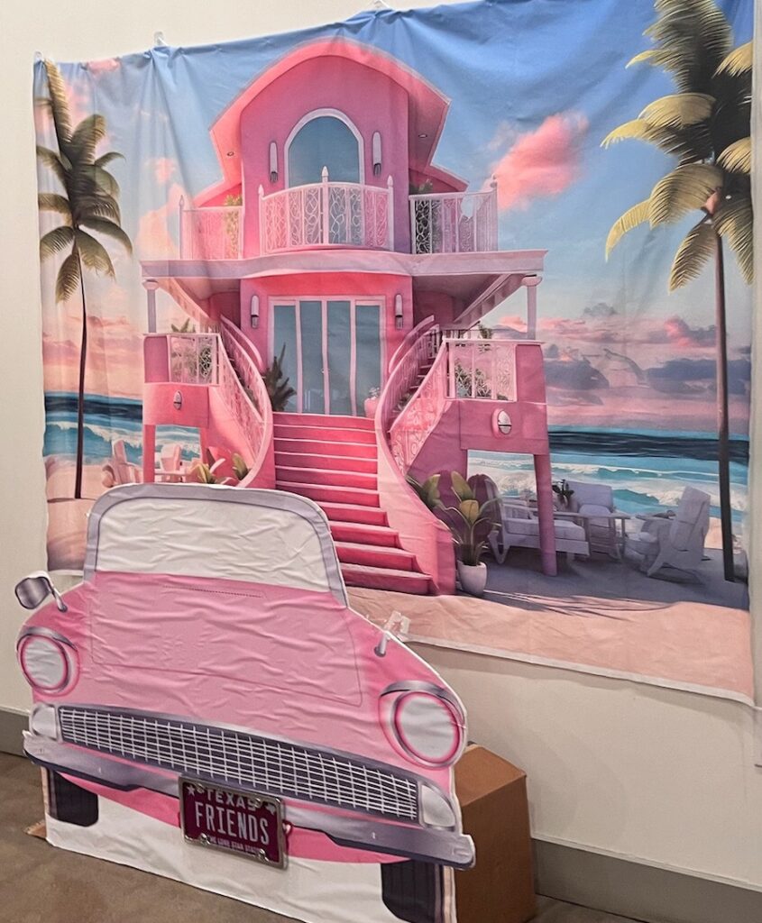 A pink Barbie house and car backdrop at a Barbie-Themed Fundraiser event