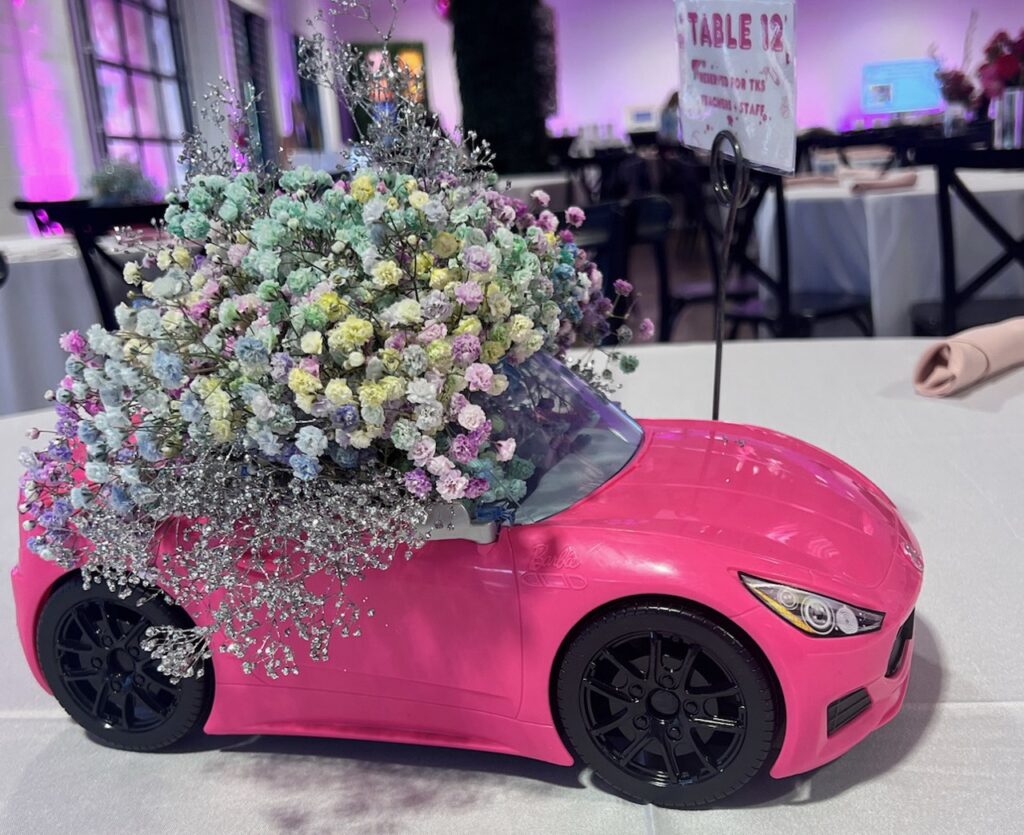 A pink toy car with flowers on it at a Barbie-Themed Fundraiser event