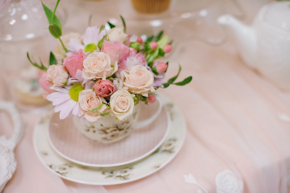 A cup of flowers on a plate is a great wedding theme fundraiser venue table decor idea