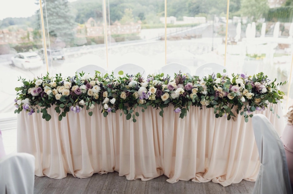 A table with flowers on it is a great wedding theme fundraiser venue decor idea