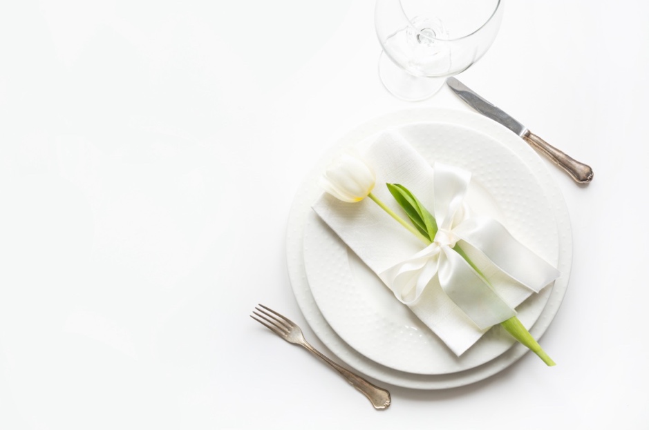A white plate with a flower on it is a great wedding theme fundraiser venue place setting idea