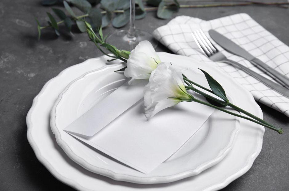 A white plate with flowers on it is a great wedding theme fundraiser venue place setting idea