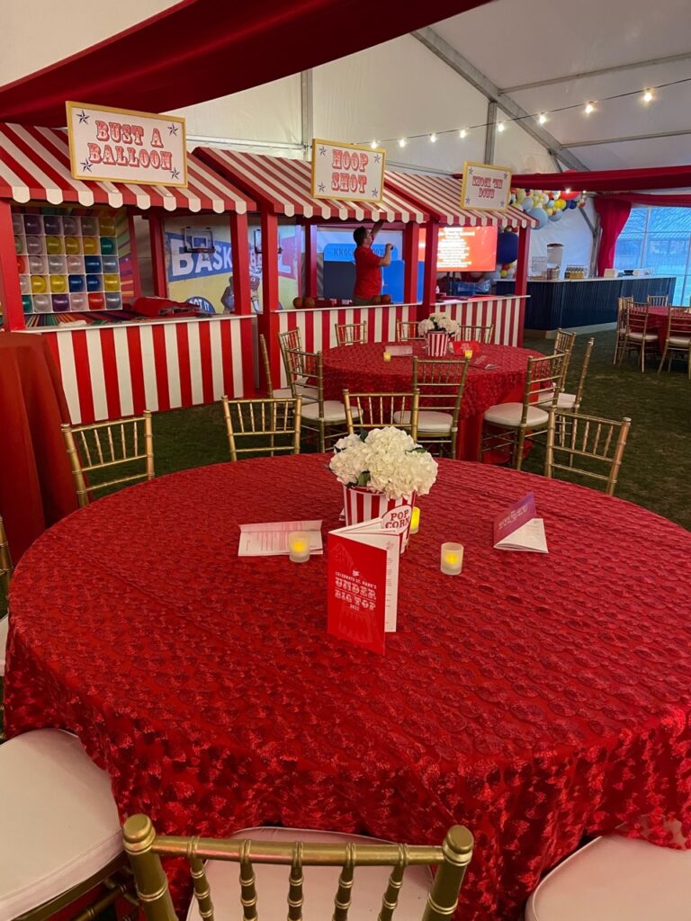 A round red table with white striped tents and red and white striped tents
are great Table Décor for a circus fundraiser theme.