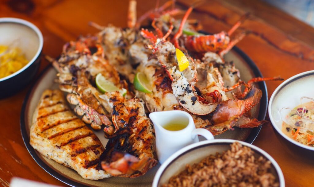 A plate of grilled seafood on a table for a Sand and Sea or Yacht Theme Fundraiser.