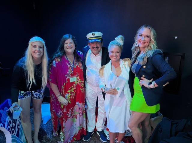 A group of people posing for a photo for a Sand and Sea Fundraiser.