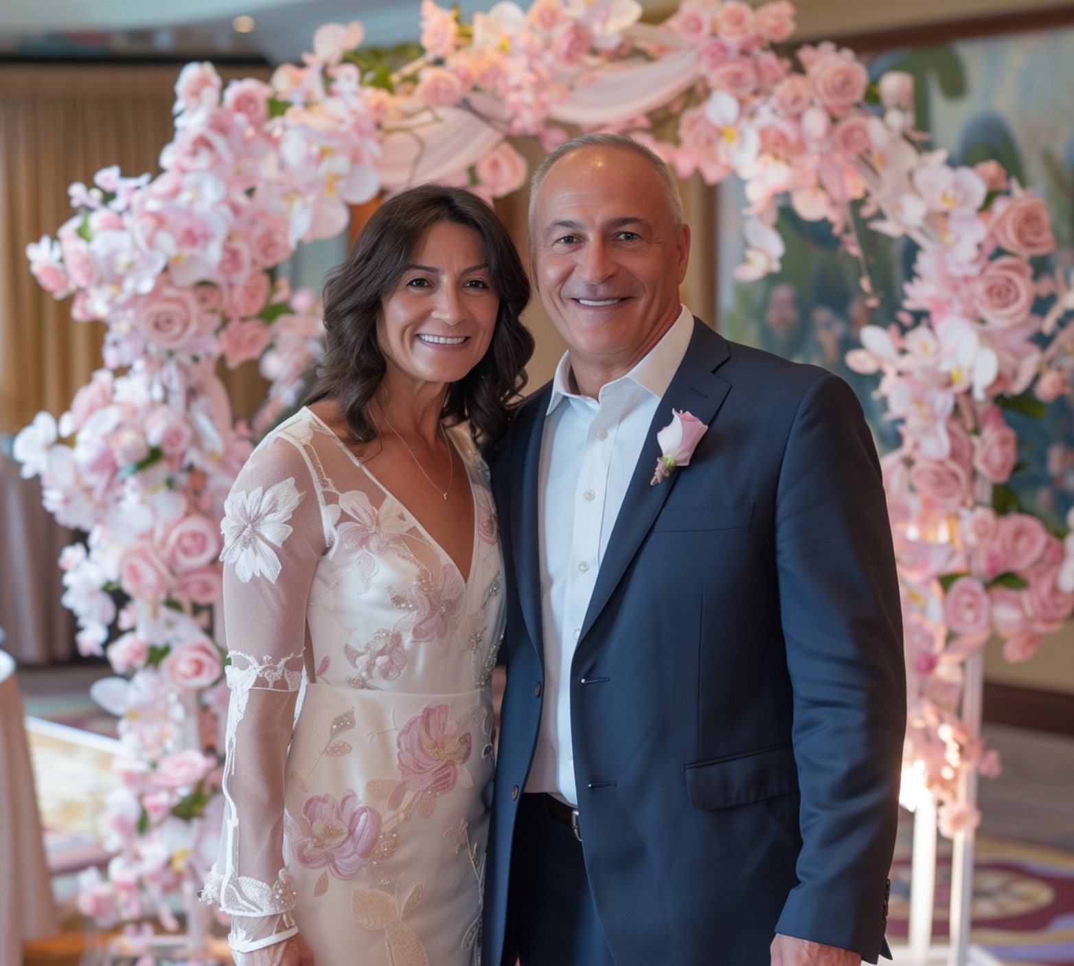 A couple standing in front of a floral arch flower backdrop for a fundraiser photo booth.