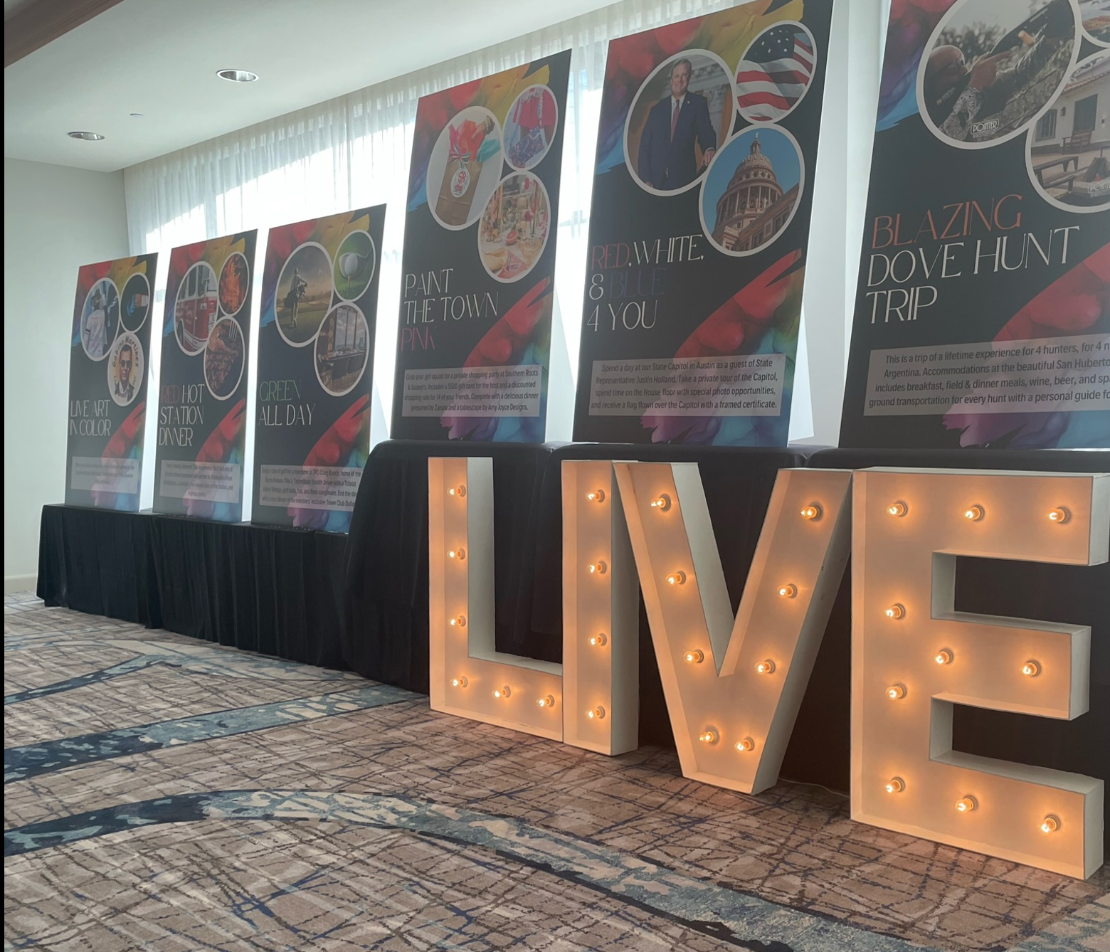 A group of auction item signs on a stage
