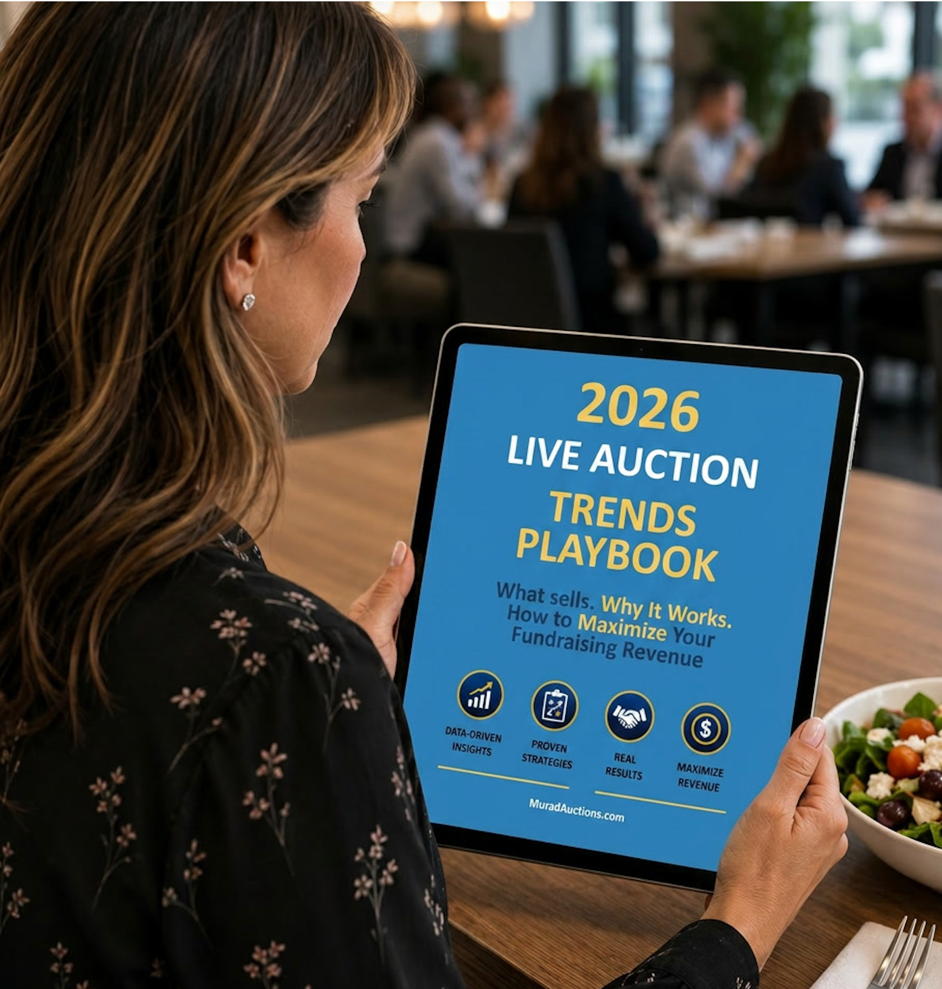 Nonprofit professional viewing 2026 Live Auction Trends Playbook on tablet during meeting